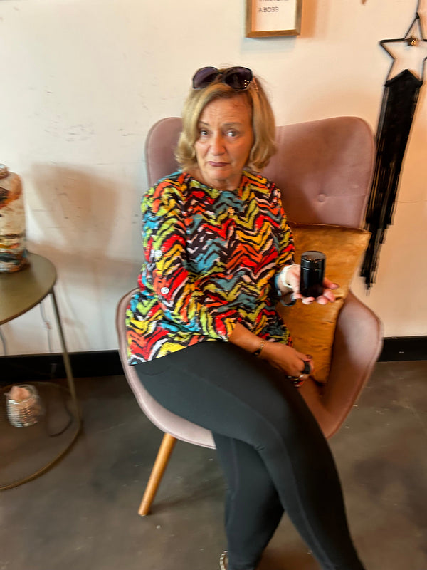 Person sitting on a chair with a colorful shirt in an indoor setting