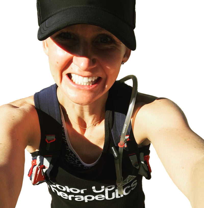 Person in athletic wear with "color up therapeutics" with a hydration pack outdoors