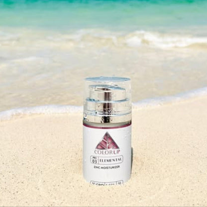 Skincare bottle labeled 'ColorUP' on a sandy beach with ocean in the background