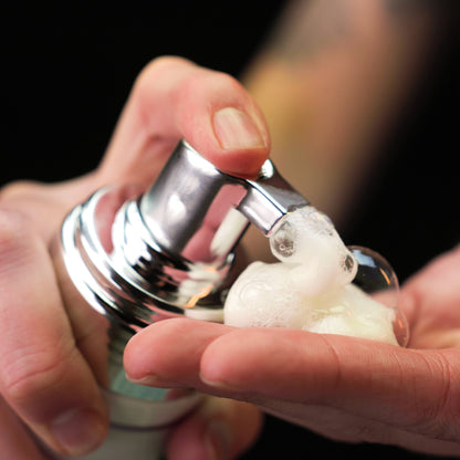 Person pumping out 'Color Up Remove Foaming Cleanser" from silver bottle, into their hands