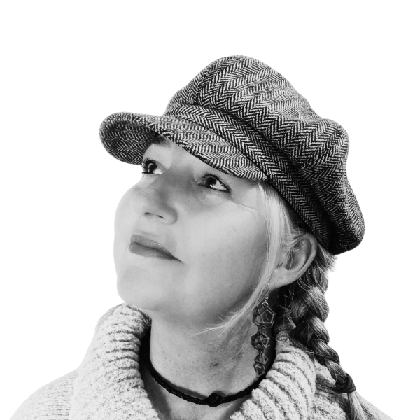 Black and white photo of a person wearing a patterned hat and braided hair.