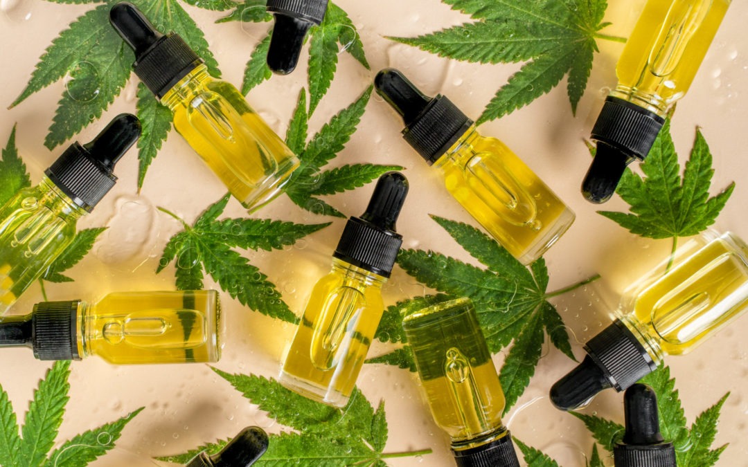 various bottles of cbn vs cbd vs cbg laid on a table with cannabis leaves