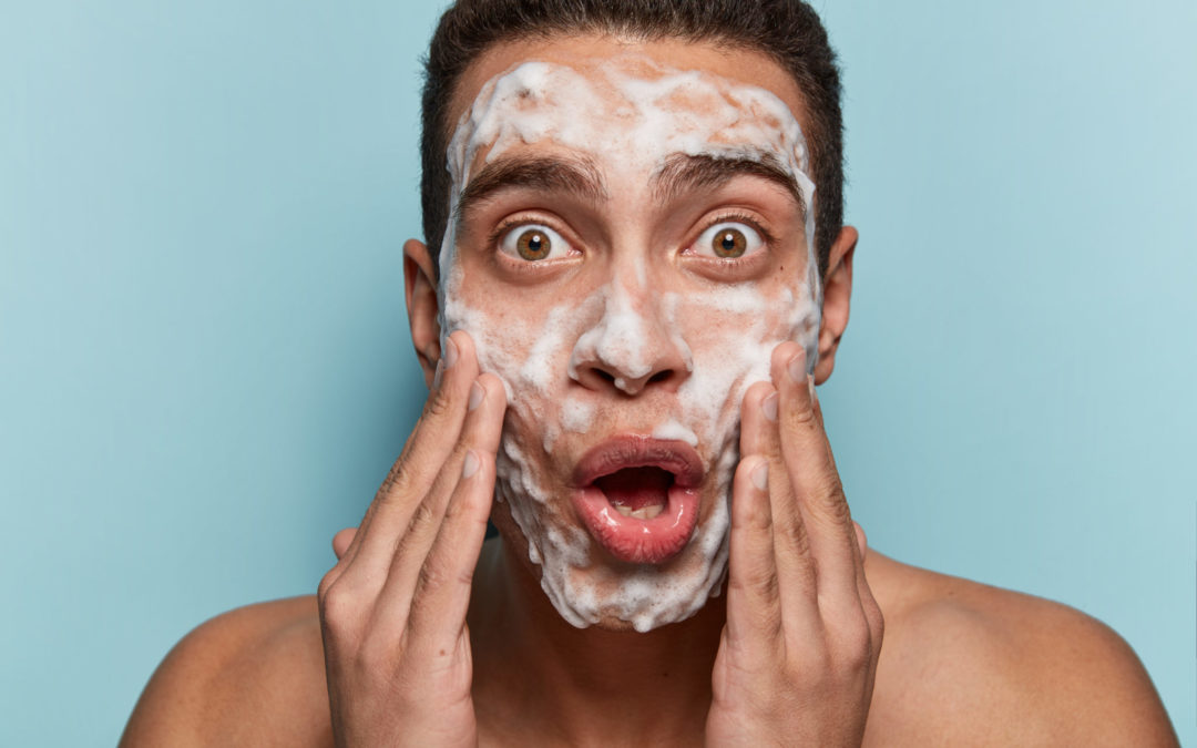 man washing his face using cbd skincare cleanser