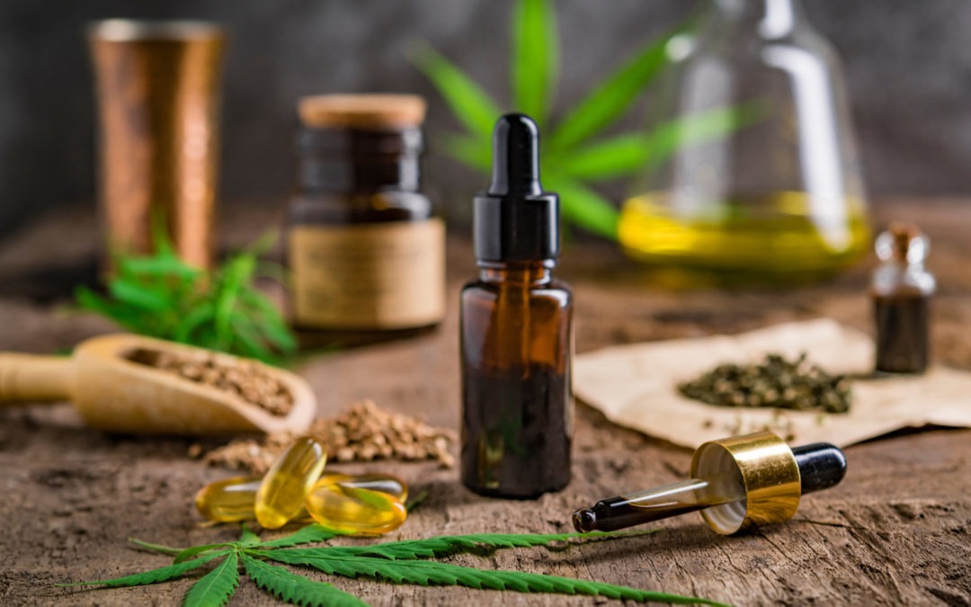 hemp essential oil CBD product in small glass bottle. container with cannabis leaves and cannabis seeds on wooden.
