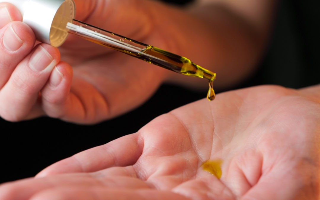 close up of hands dropping cbd oil onto palms cbd for beginners